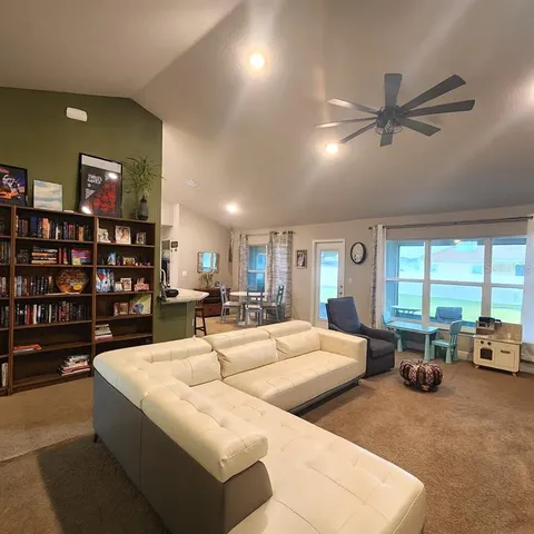 a large living room with furniture a flat screen tv and a fireplace