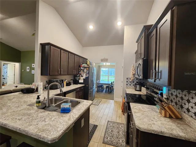 a kitchen with sink stove dining table and chairs