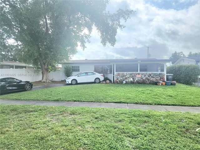 a front view of a house with a garden and trees