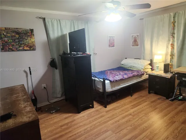 a bedroom with a bed and a flat tv screen on the dresser