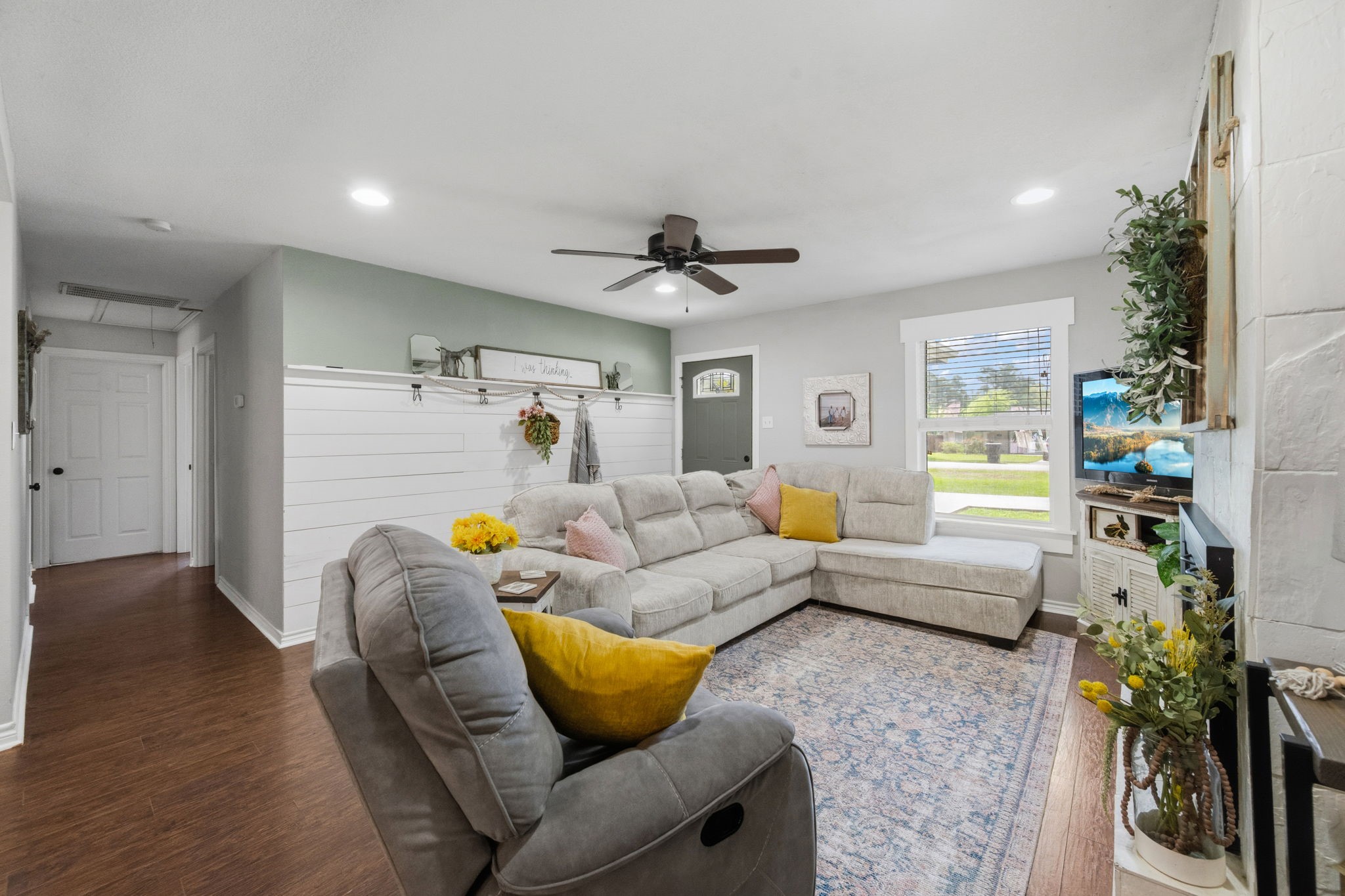 431 Corydon Drive Houston, TX 77336 - Photo 7 of 26 The family room is filled with natural light and soft neutral tones, creating a warm, inviting atmosphere. A striking shiplap accent wall adds depth and character to the space.