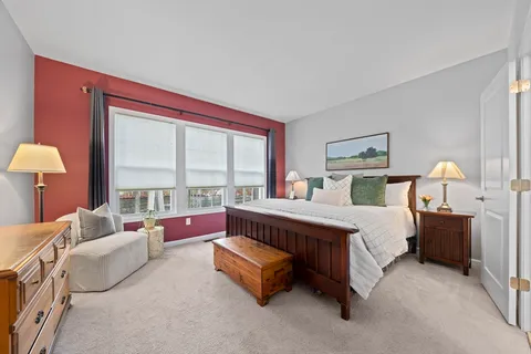 a spacious bedroom with a bed and a large window