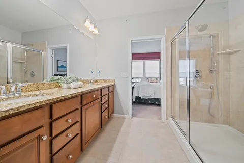 a spacious bathroom with a double vanity sink mirror and shower