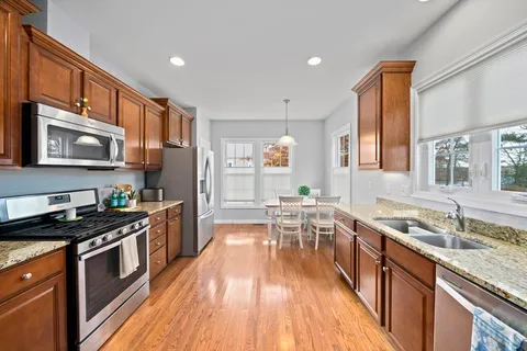 a kitchen with granite countertop a sink a counter top space stainless steel appliances and cabinets