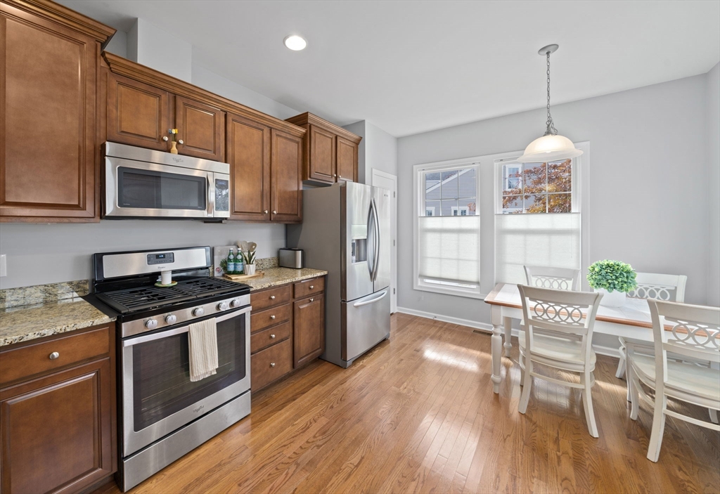33 Kelly Way, Unit 33 Canton, MA 02021 - Photo 5 of 42 a kitchen with granite countertop wooden floors appliances and dining table