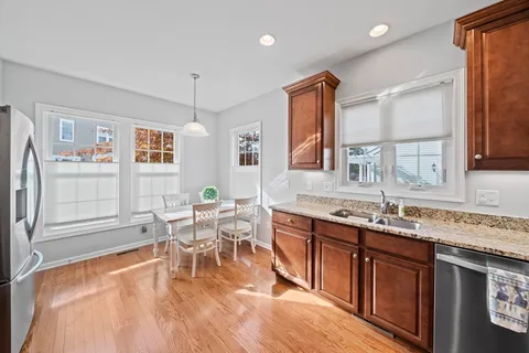 a kitchen with stainless steel appliances granite countertop a sink stove and wooden cabinets