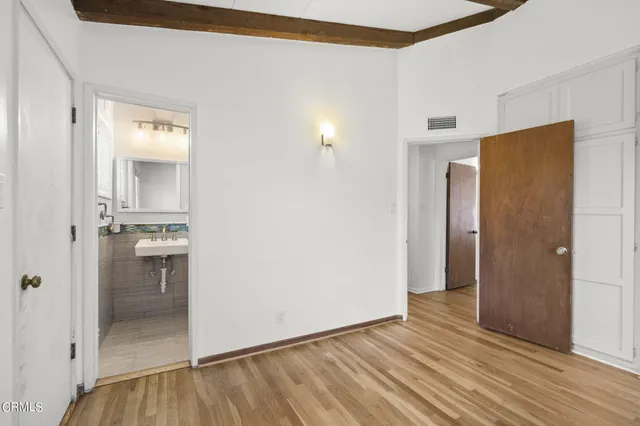 a view of a room with wooden floor and a kitchen
