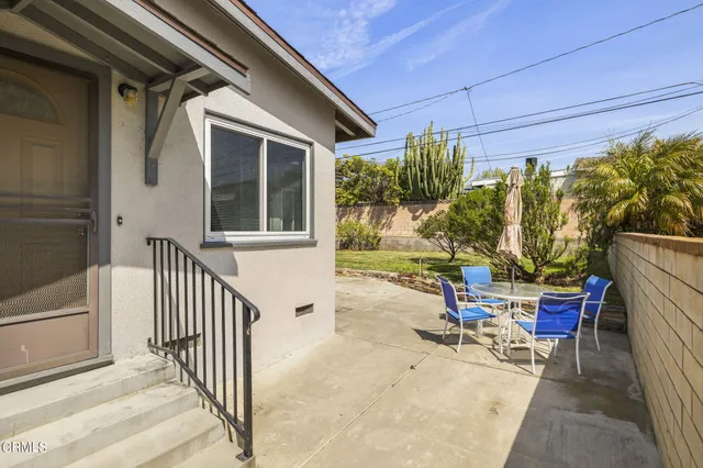 a view of a patio with a table and chairs and potted plants