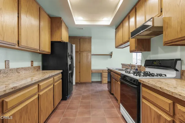 a kitchen with stainless steel appliances granite countertop a stove a sink and a refrigerator