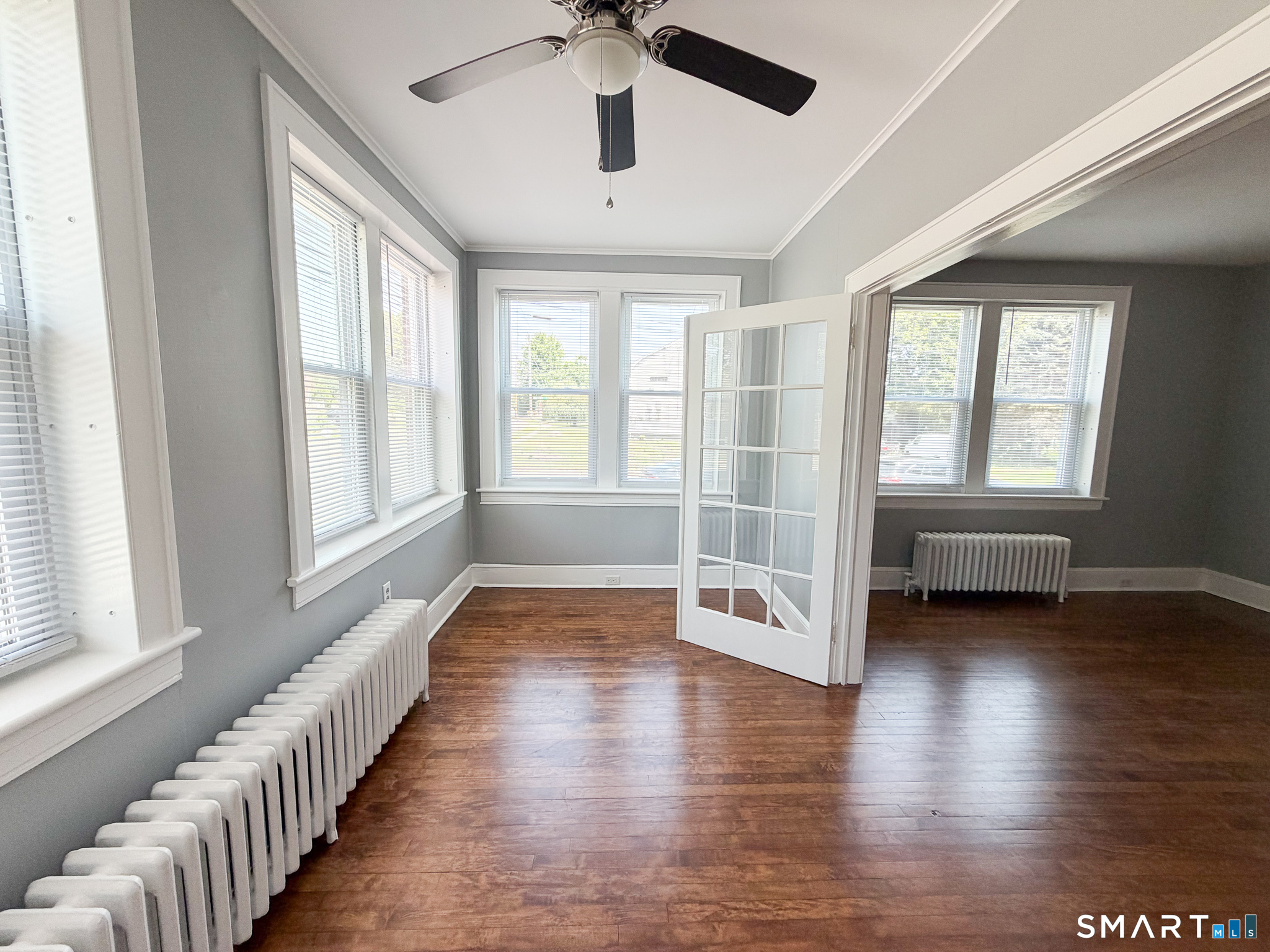 793 Milford Point Road, Unit 1 Milford, CT 06460 - Photo 7 of 16 a view of an empty room with wooden floor and a window