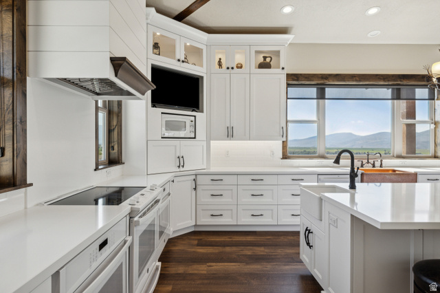 6117 North Rocky Ridge Road Peoa, UT 84061 - Photo 45 of 82 Modern kitchen featuring white cabinetry, wood-finish flooring, a farmhouse sink, integrated appliances, and extensive countertop space