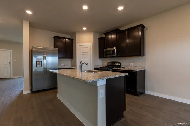 a kitchen with stainless steel appliances granite countertop a sink and a refrigerator