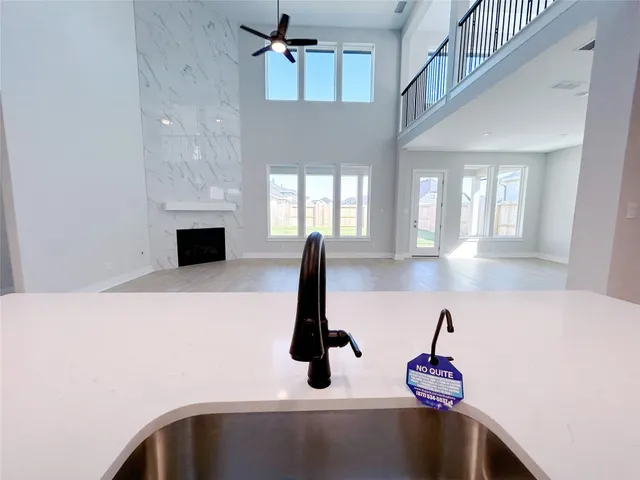 a kitchen with white cabinets a sink dishwasher and a fireplace with wooden floor