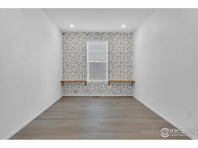 a open kitchen with a fireplace a ceiling fan and wooden floor
