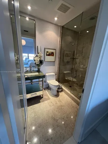 a bathroom with a glass door shower and toilet