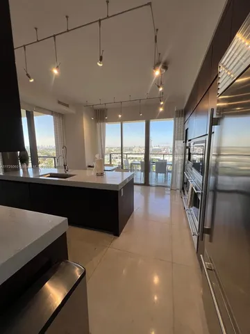 a large kitchen with a large counter top appliances and cabinets