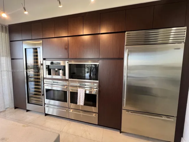 a kitchen with stainless steel appliances and refrigerator