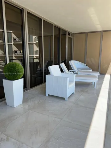 a living room with a balcony a bed and a couch