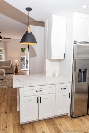 a kitchen with white cabinets and sink