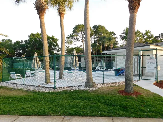 a view of a house with backyard and a tree