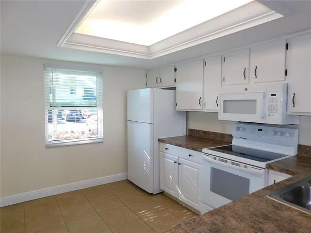 a kitchen with cabinets appliances a sink and a window