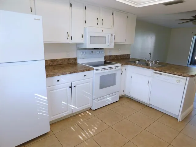 a kitchen with granite countertop white cabinets and stainless steel appliances