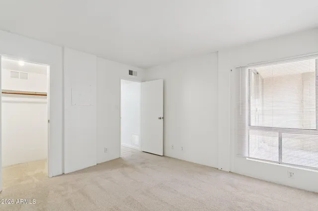 an empty room with windows and closet