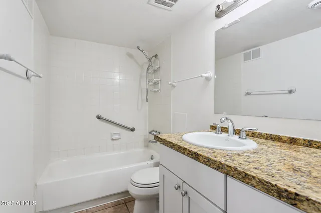 a bathroom with a granite countertop sink toilet and shower