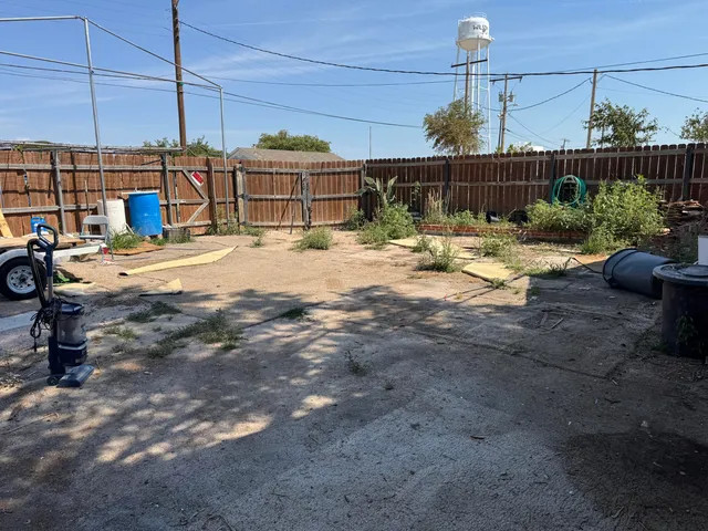 a view of a patio with a table and chairs potted plants