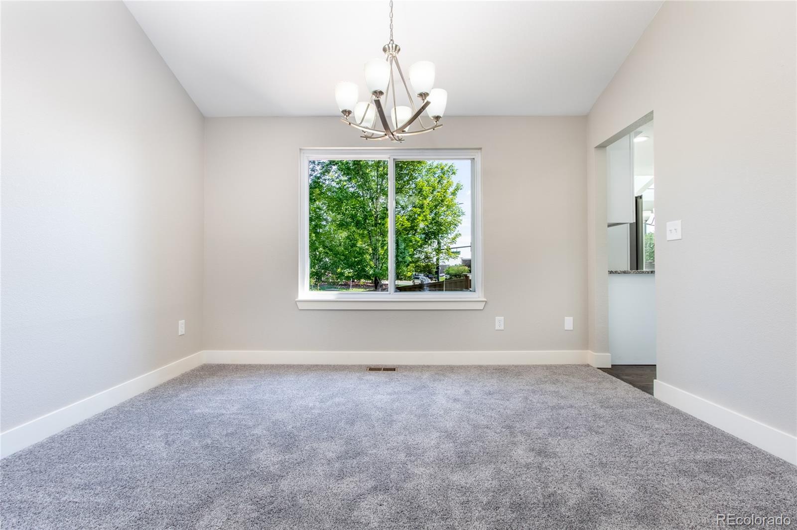 2505 Spring Hill Court Highlands Ranch, CO 80129 - Photo 11 of 40 an empty room with windows and a chandelier