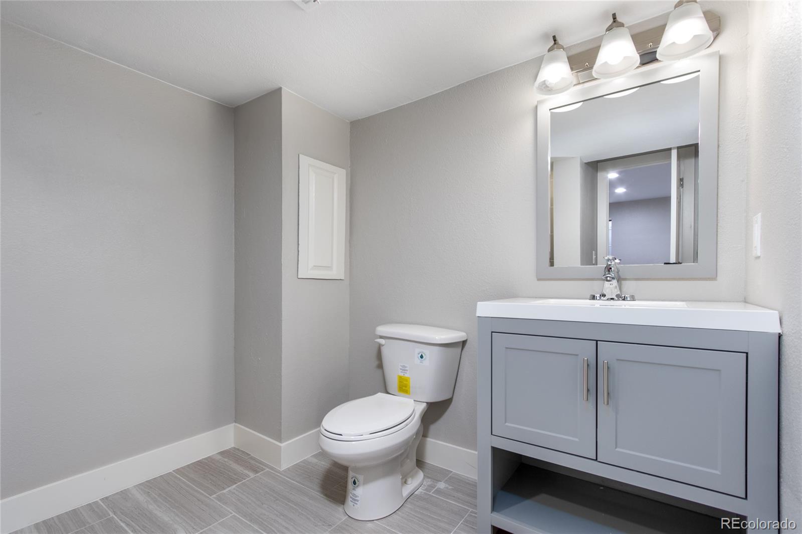 2505 Spring Hill Court Highlands Ranch, CO 80129 - Photo 26 of 40 a bathroom with a toilet a sink a vanity and mirror