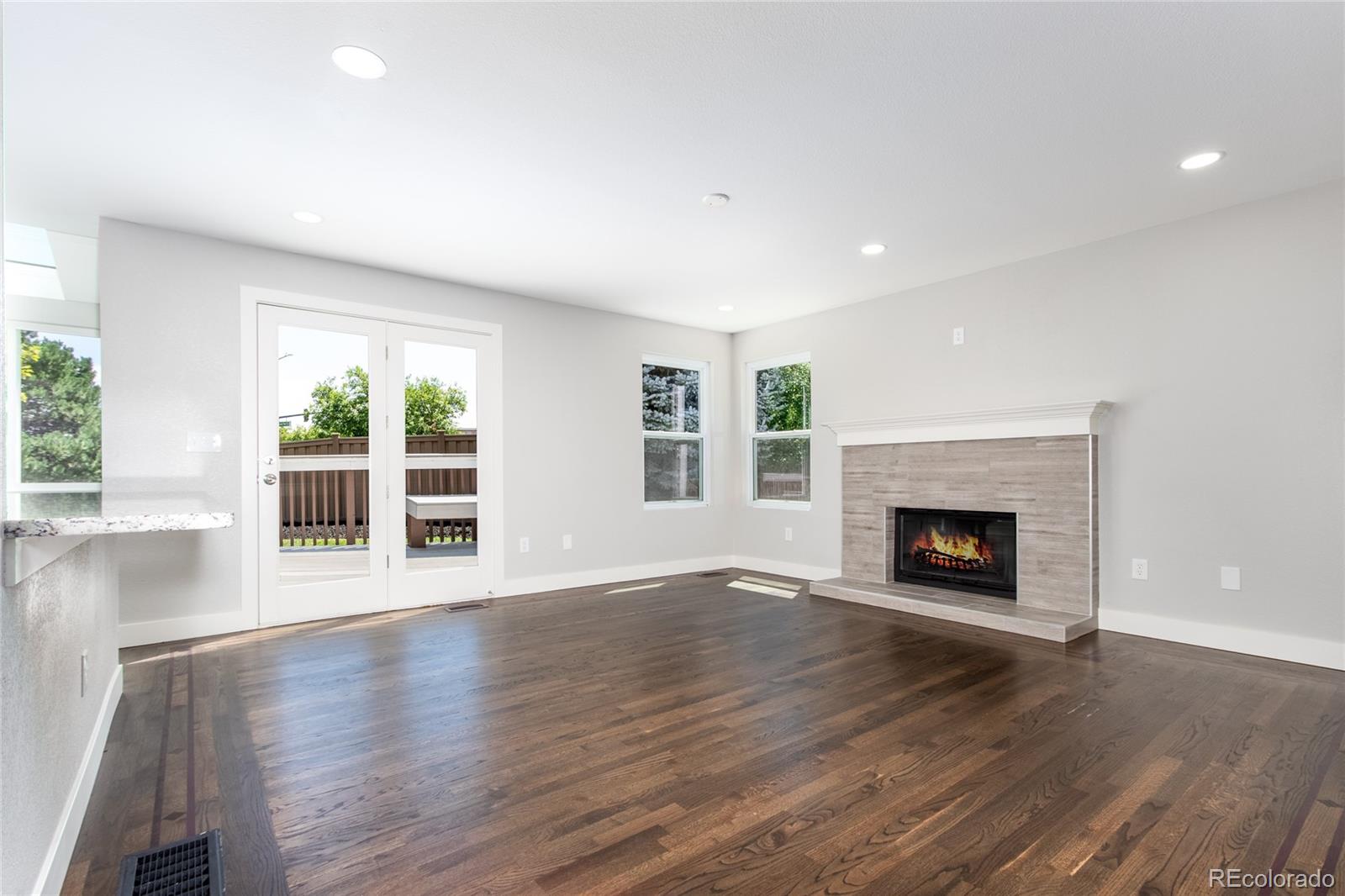 2505 Spring Hill Court Highlands Ranch, CO 80129 - Photo 9 of 40 an empty room with wooden floor fireplace and windows