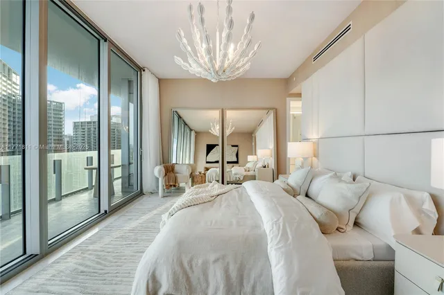a bedroom with a large bed and a chandelier