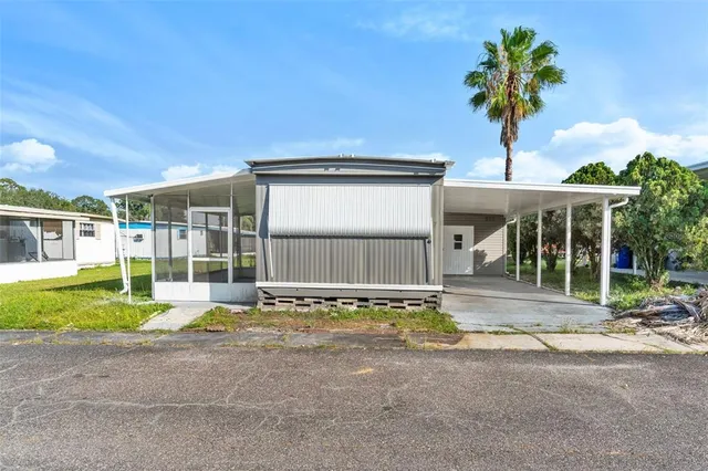 a view of a house with backyard and sitting area