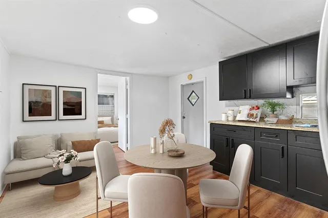 a kitchen with stainless steel appliances granite countertop a table and chairs