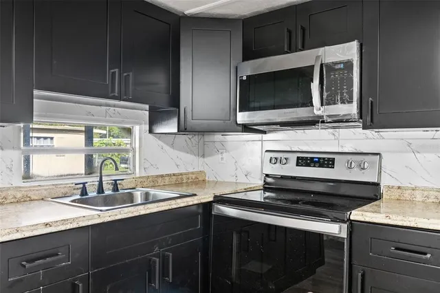 a kitchen with a stove microwave and sink