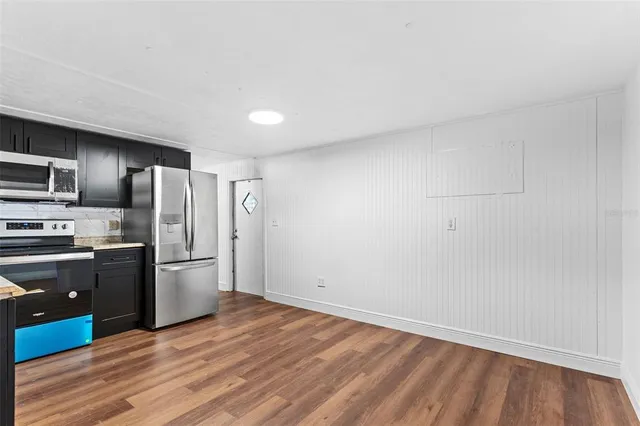 a kitchen with granite countertop a refrigerator and a stove top oven