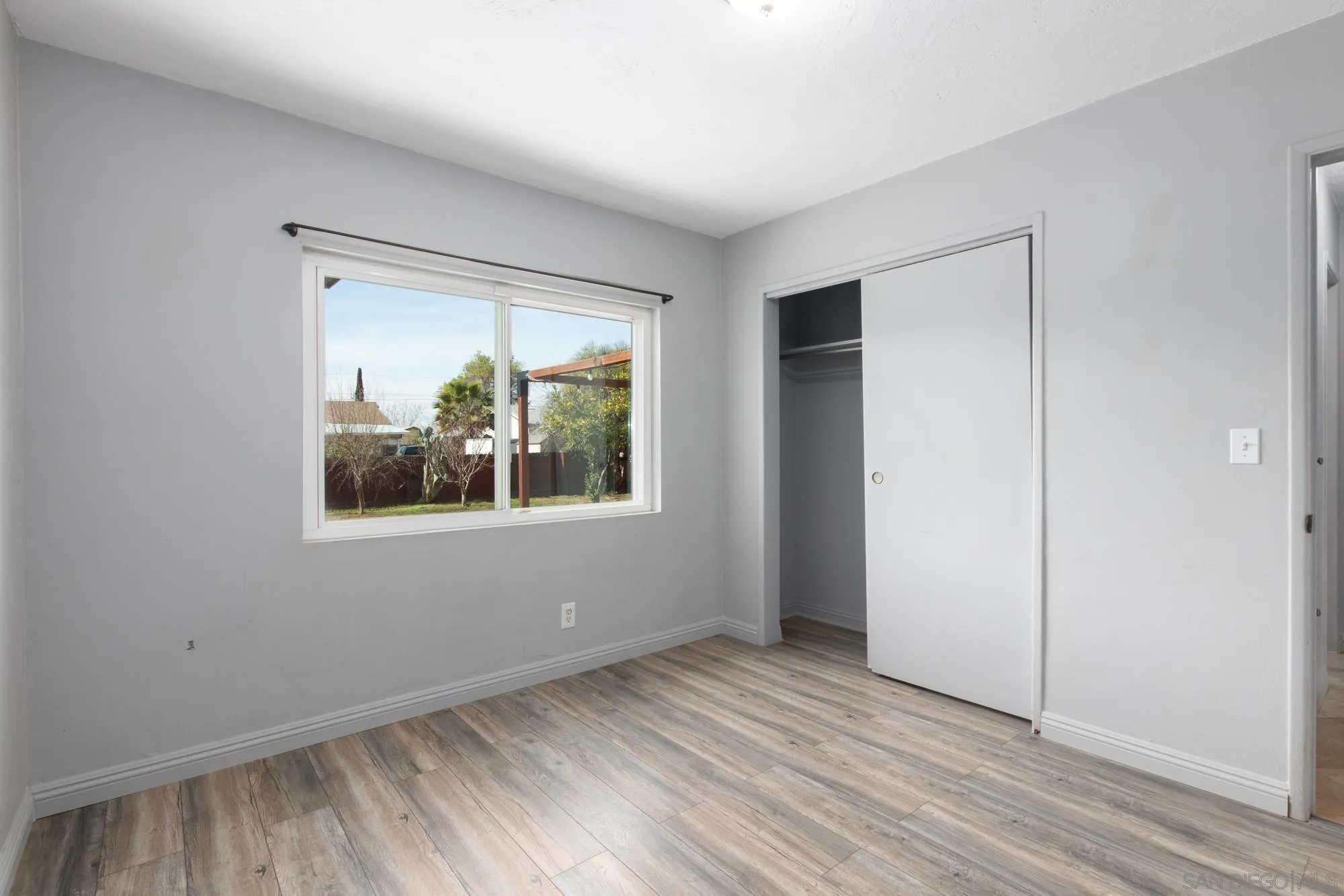 909 North Midway Drive Escondido, CA 92027 - Photo 12 of 19 an empty room with wooden floor and windows