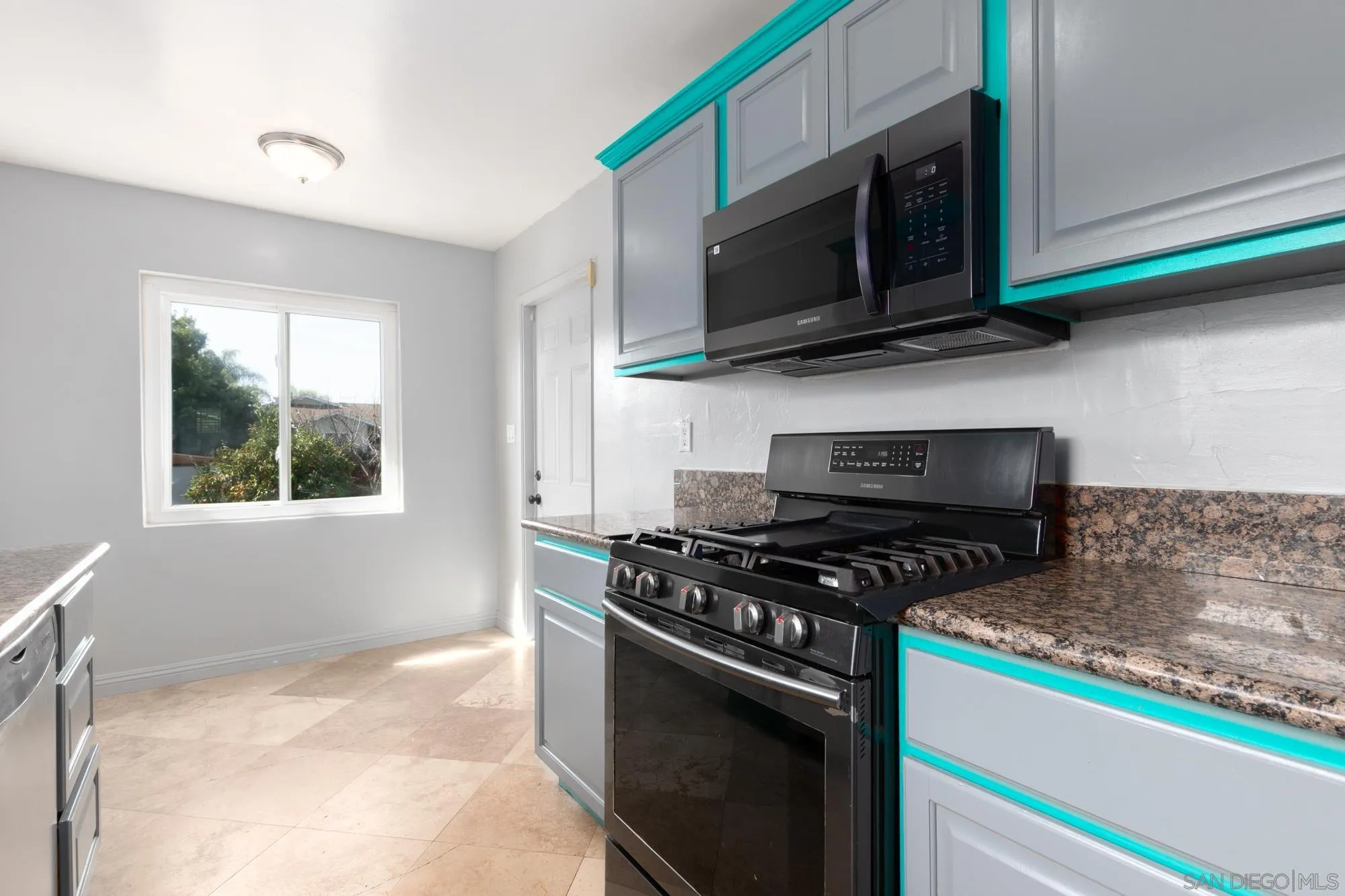 909 North Midway Drive Escondido, CA 92027 - Photo 3 of 19 a kitchen with stainless steel appliances granite countertop a stove and a microwave