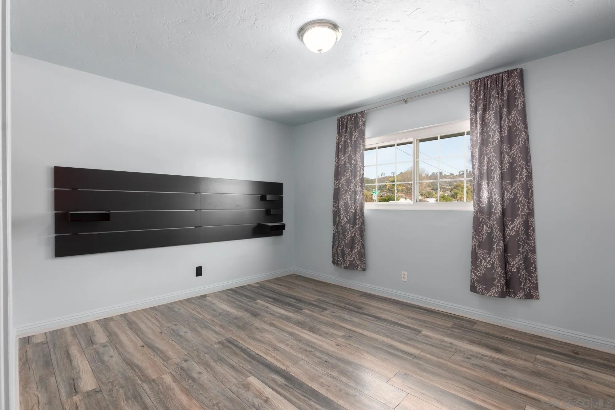 909 North Midway Drive Escondido, CA 92027 - Photo 7 of 19 a view of empty room with wooden floor and fan