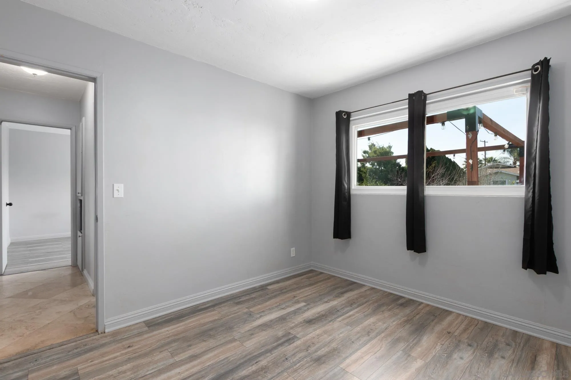 909 North Midway Drive Escondido, CA 92027 - Photo 10 of 19 an empty room with wooden floor and windows