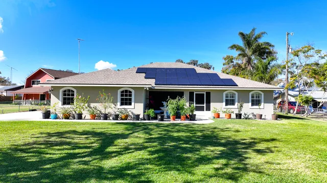a front view of a house with a garden and trees