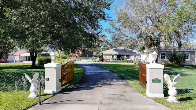 a front view of a house with a garden and trees