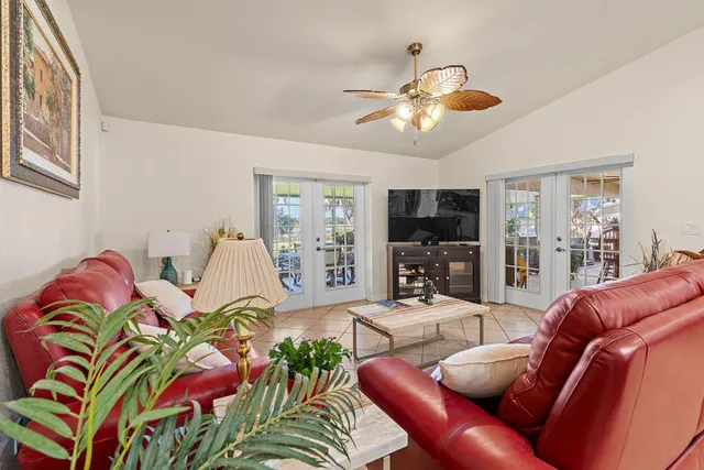 a living room with furniture a flat screen tv and a large window