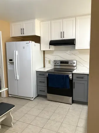 a kitchen with stainless steel appliances granite countertop a stove a refrigerator and a cabinets