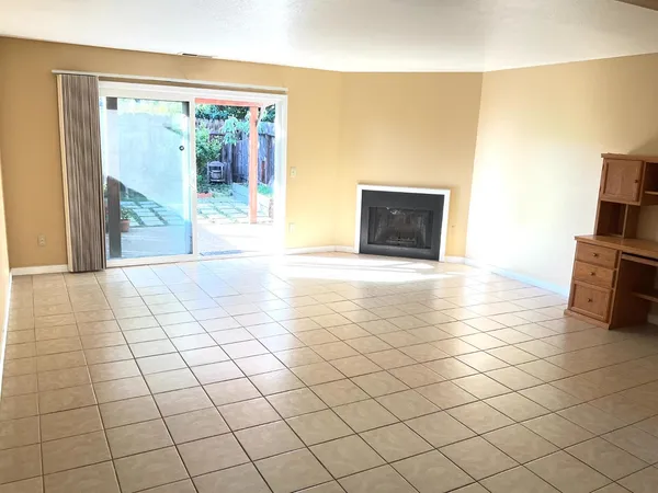 a view of an empty room with a fireplace and a large window
