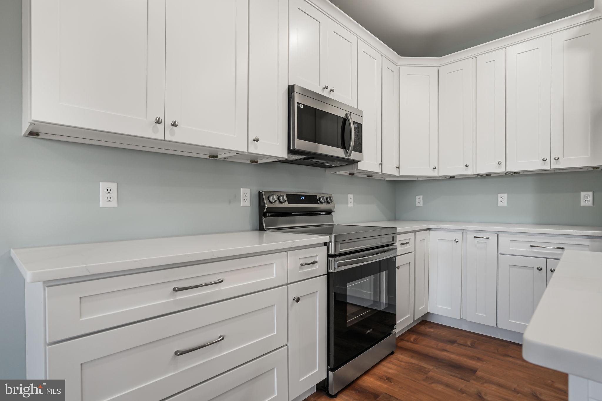 7921 East Side Road Chincoteague Island, VA 23336 - Photo 11 of 38 a kitchen with white cabinets stainless steel appliances and sink