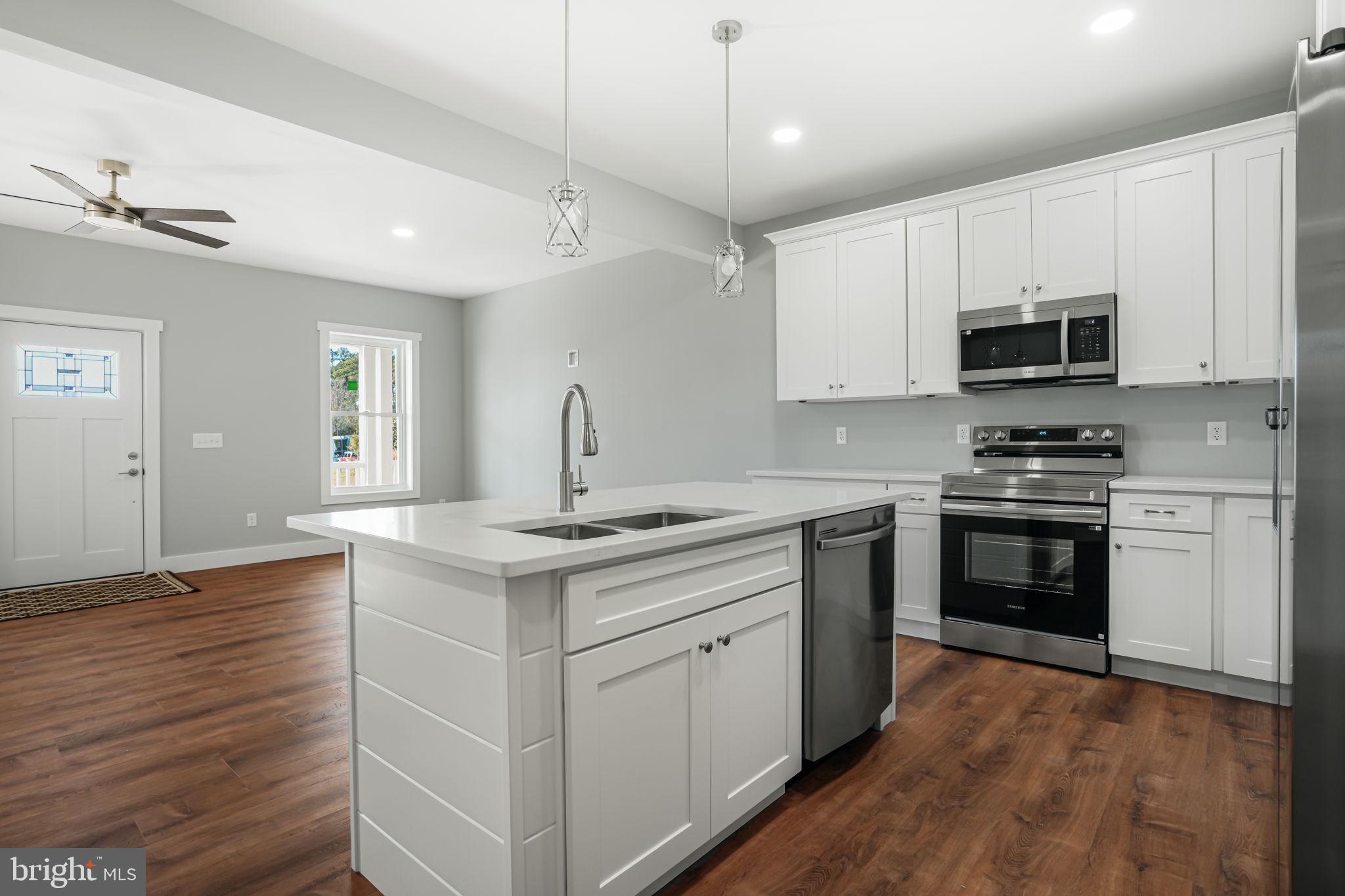 7921 East Side Road Chincoteague Island, VA 23336 - Photo 13 of 38 a kitchen with stainless steel appliances granite countertop a stove and a sink