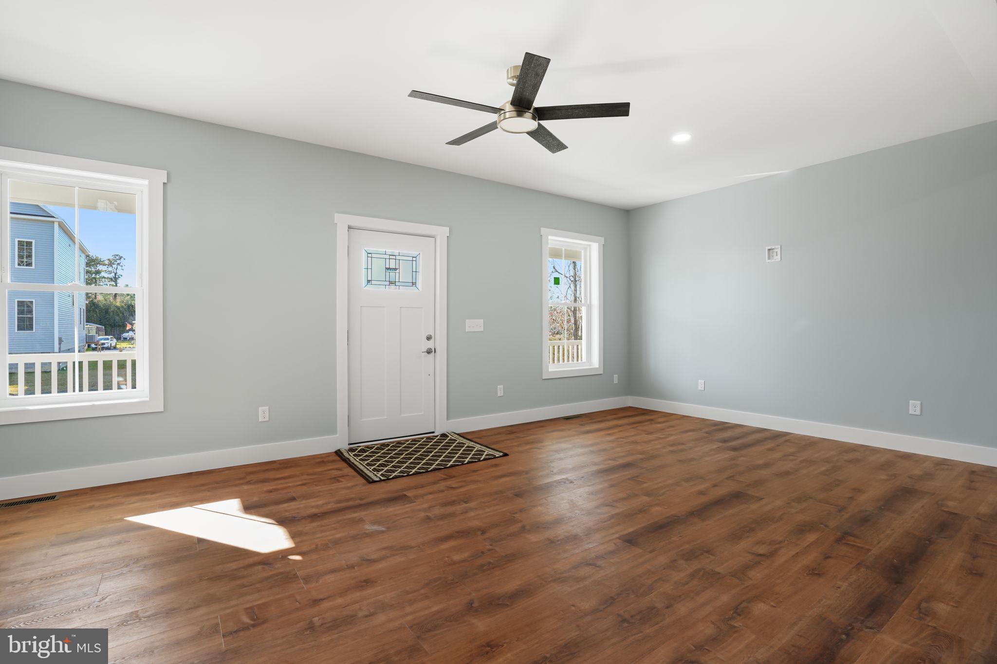 7921 East Side Road Chincoteague Island, VA 23336 - Photo 8 of 38 wooden floor in an empty room with a window