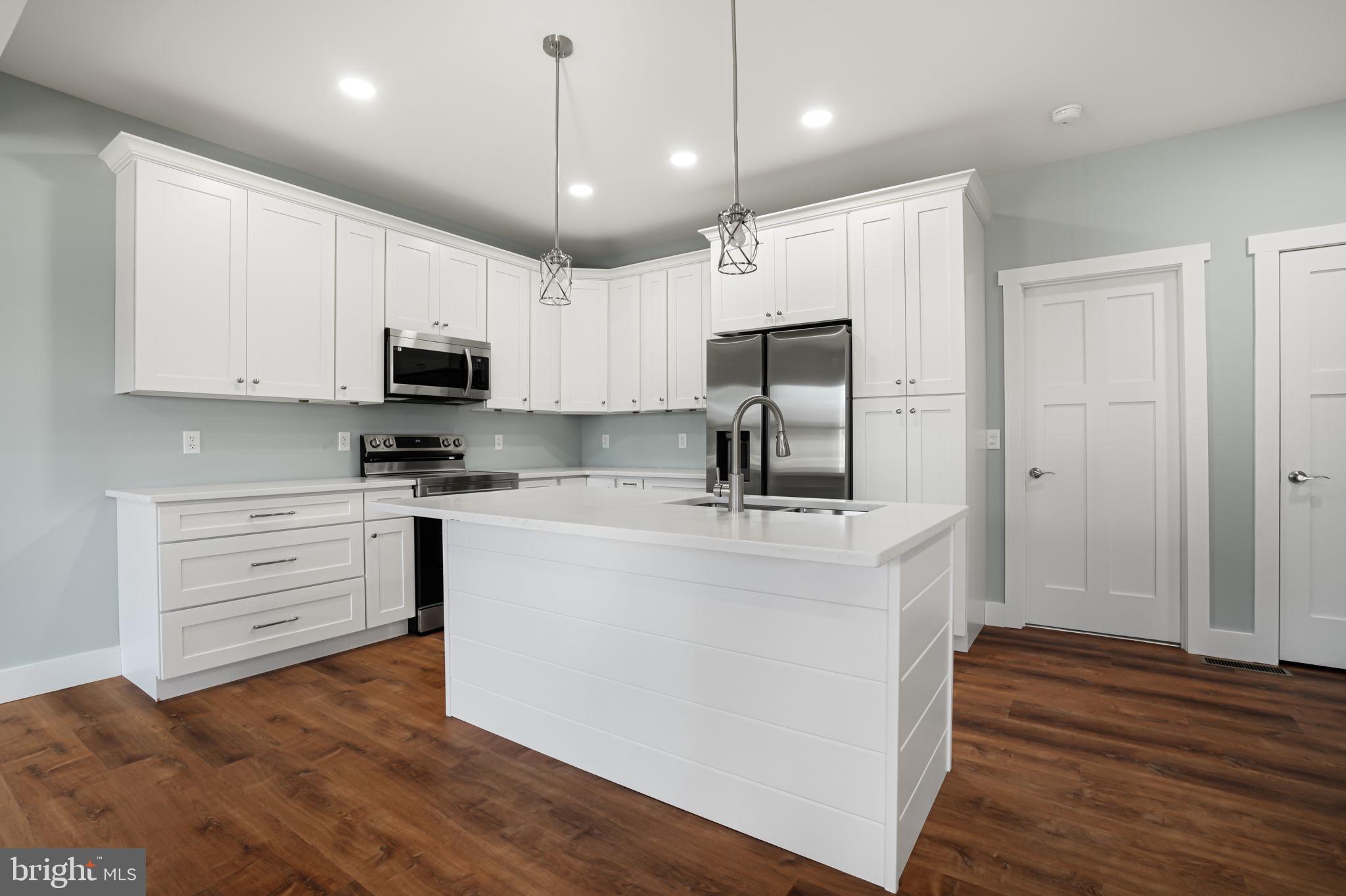 7921 East Side Road Chincoteague Island, VA 23336 - Photo 9 of 38 a kitchen with kitchen island a white counter top space cabinets and stainless steel appliances
